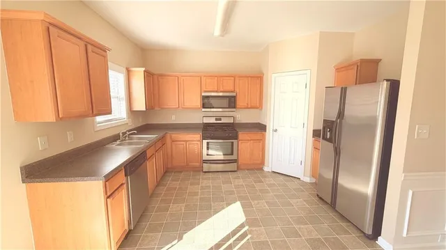 a kitchen with stainless steel appliances granite countertop a refrigerator and a sink