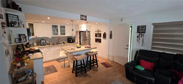 a living room with furniture and a dining table with wooden floor