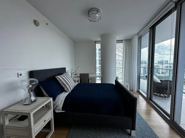 a bedroom with a bed and large window