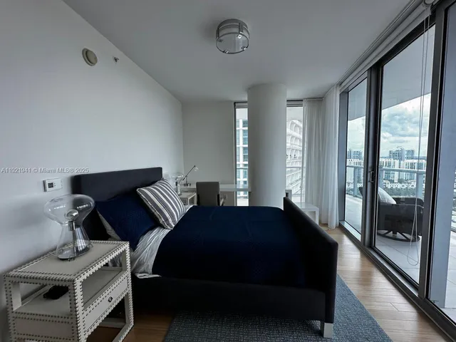 a bedroom with a bed and large window