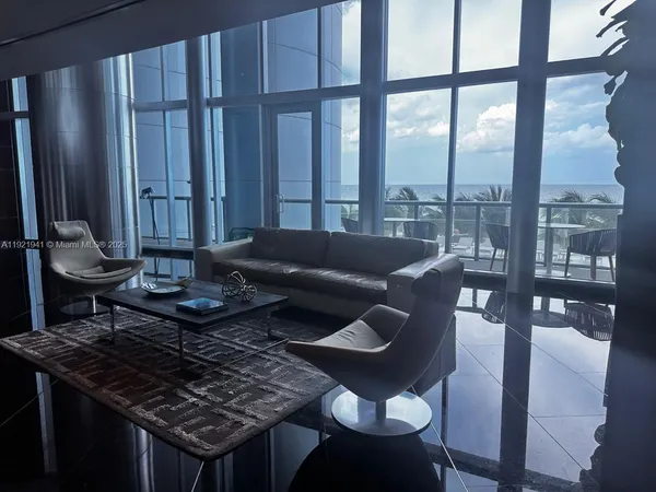 a living room with furniture and a floor to ceiling window
