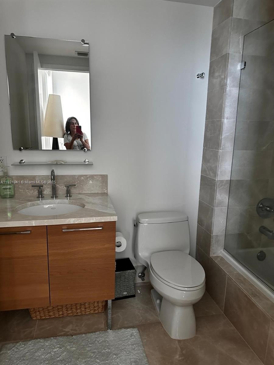 17001 Collins Avenue, Unit 2601 Sunny Isles Beach, FL 33160 - Photo 10 of 27 a bathroom with a toilet a sink and shower