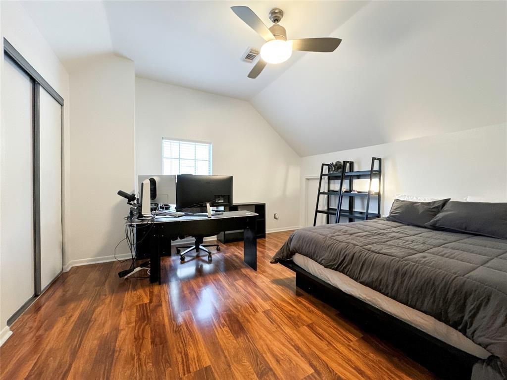5202 Spring Cir Drive Pearland, TX 77584 - Photo 12 of 19 a living room with a bed and a wooden floor