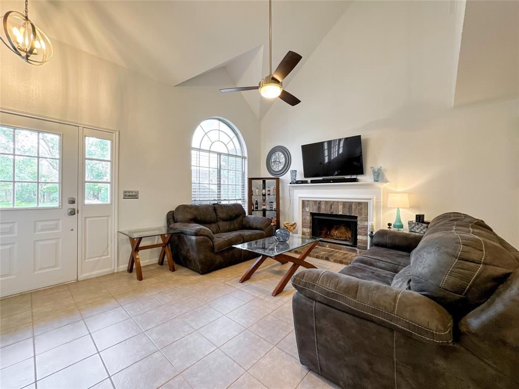 5202 Spring Cir Drive Pearland, TX 77584 - Photo 2 of 19 a living room with furniture a fireplace and a flat screen tv