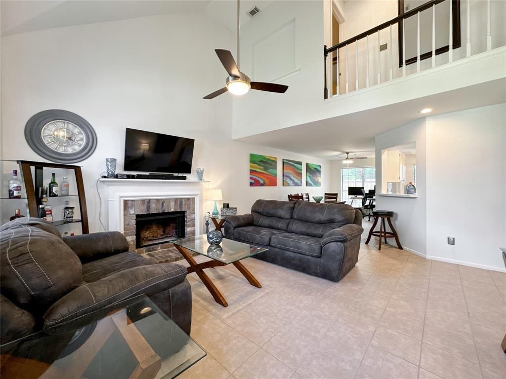 5202 Spring Cir Drive Pearland, TX 77584 - Photo 3 of 19 a living room with furniture a fireplace and a flat screen tv