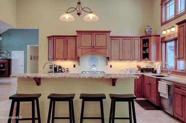 a kitchen with kitchen island granite countertop a table chairs in it and wooden floors