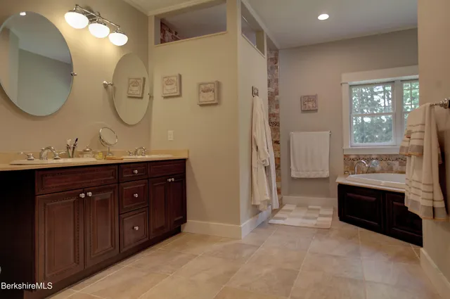a spacious bathroom with a granite countertop double vanity and a mirror