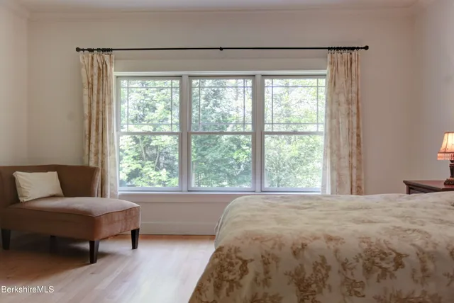 a bedroom with a bed and a couch next to a window