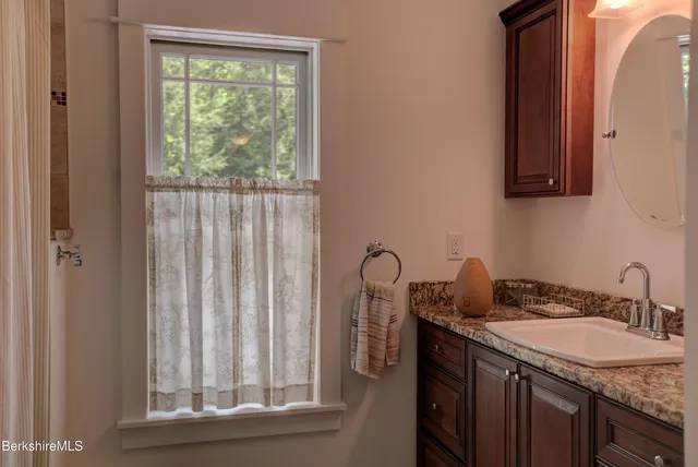 a bathroom with a granite countertop sink and a mirror