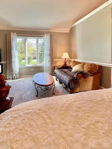 a spacious bedroom with a bed and a chandelier