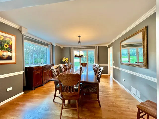 a view of a dining room with furniture a chandelier and wooden floor