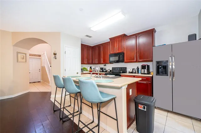 a kitchen with stainless steel appliances granite countertop wooden cabinets a dining table and chairs