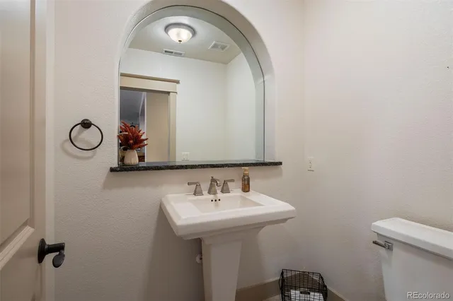 a bedroom with a bed a dresser and painting on the wall