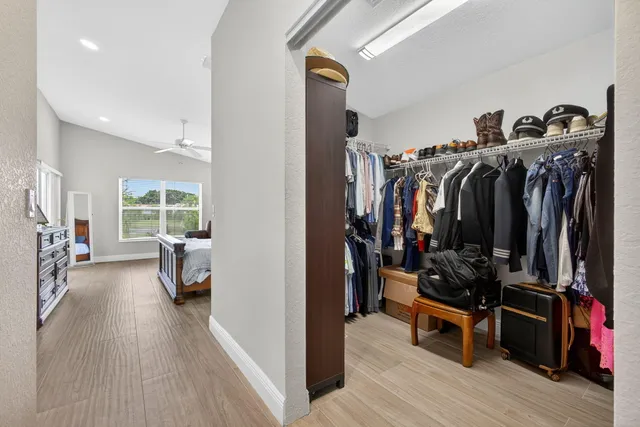 a view of a walk in closet with clothes and shoes