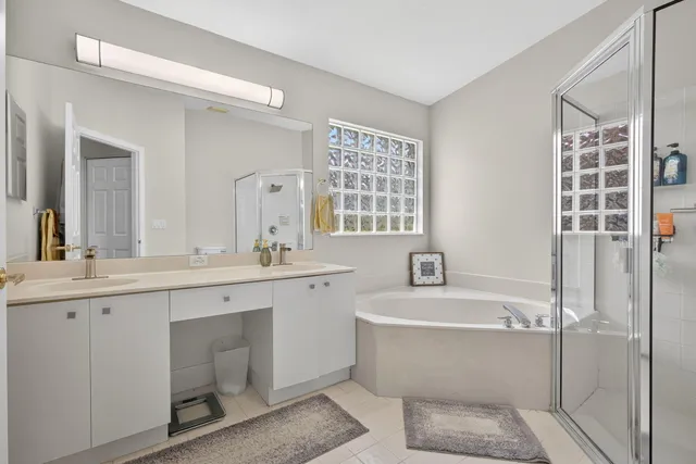 a bathroom with a bathtub a sink a window and a mirror