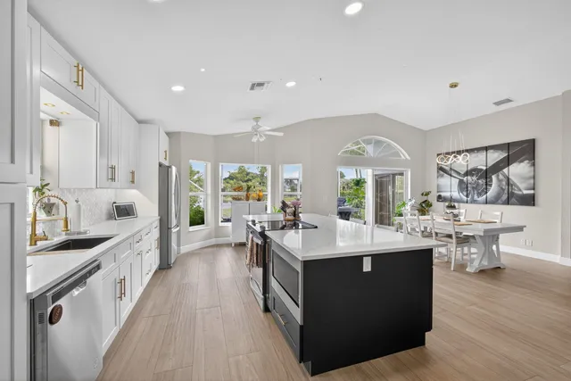 a large kitchen with kitchen island a sink a counter space and stainless steel appliances