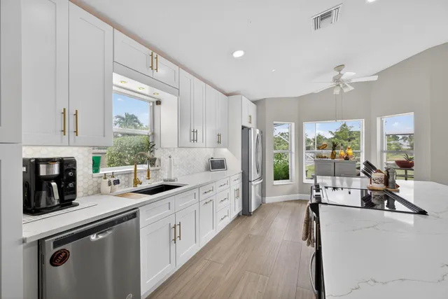 a large kitchen with stainless steel appliances lots of counter space and windows