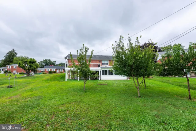 a view of house with a yard and sitting area
