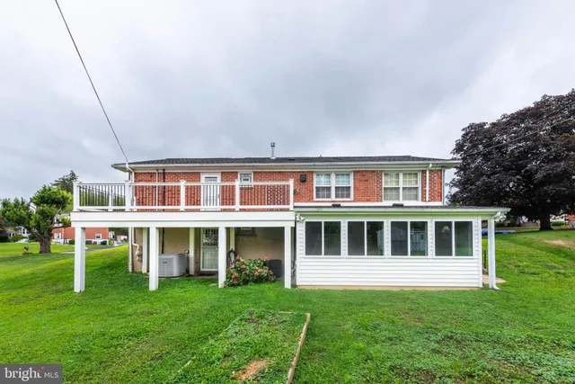 a view of a house with a big yard plants and large trees