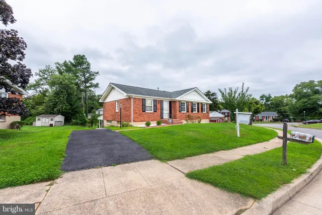 a front view of a house with a yard and trees
