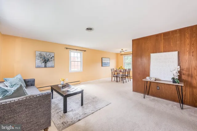 a living room with furniture a table and wooden floor