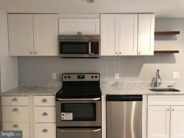 458 M Street Northwest, Unit BLOWER Washington, DC 20001 - Photo 3 of 11 a kitchen with stainless steel appliances granite countertop a sink a stove and a microwave