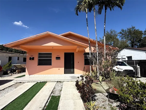 a front view of a house with a garden and patio