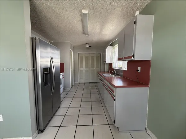 a kitchen with stainless steel appliances granite countertop a refrigerator a sink and a stove
