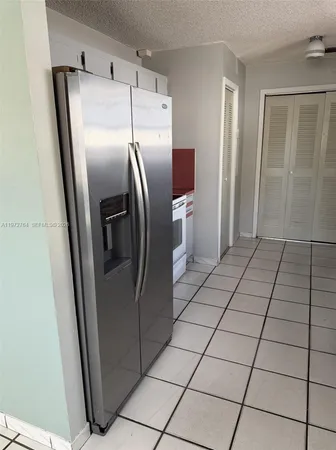 a metallic refrigerator freezer sitting in a kitchen