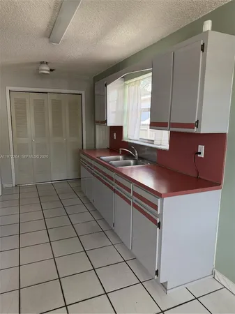 a kitchen with a sink cabinets and a window