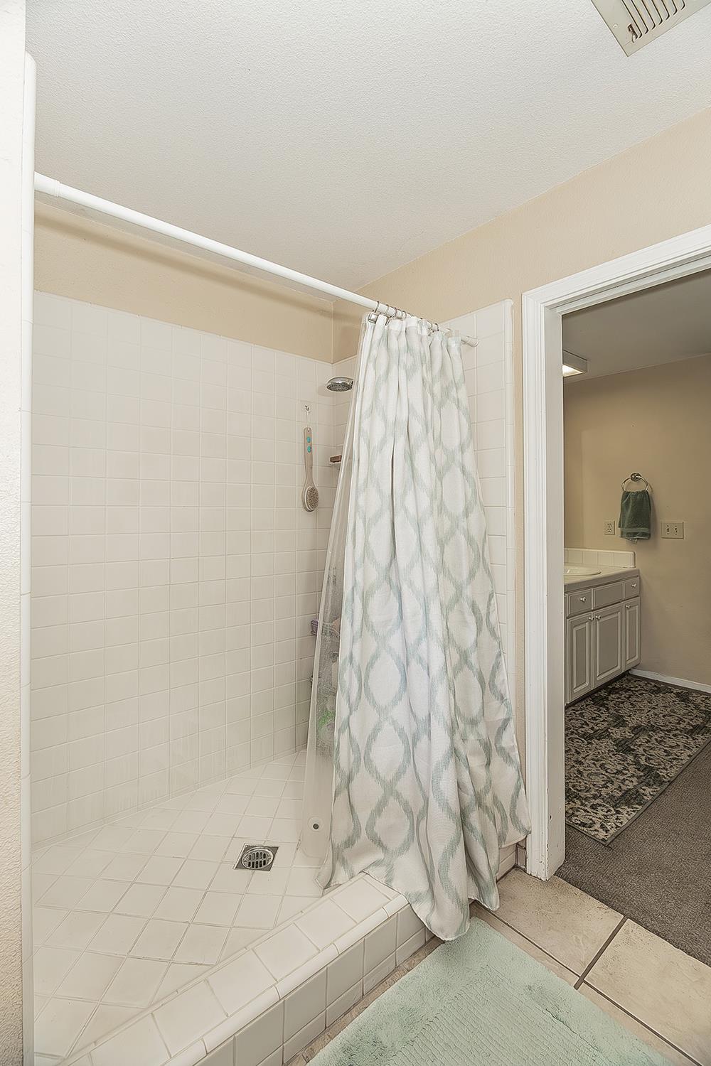14815 Garlock Lane Prather, CA 93651 - Photo 24 of 80 a bathroom with a shower curtain and a sink