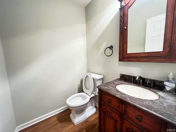 a bathroom with a granite countertop toilet sink and mirror