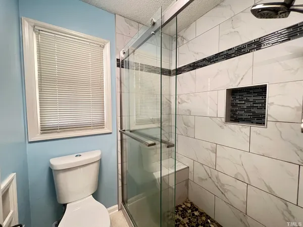 a bathroom with a toilet and a shower