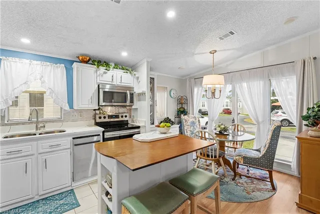 a kitchen with sink cabinets dining table and chairs