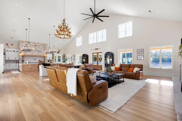 a living room with furniture a flat screen tv and a floor to ceiling window