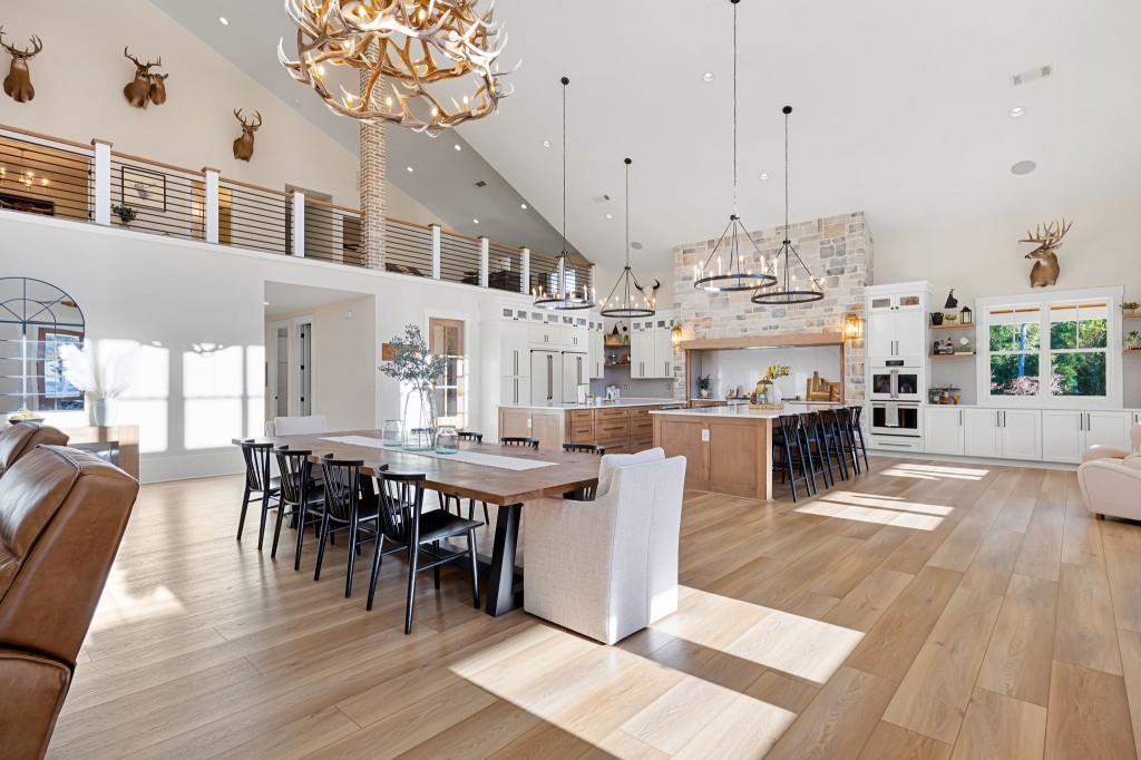 125 Perry Road Rydal, GA 30171 - Photo 36 of 139 a view of a dining room and livingroom with furniture wooden floor a rug a fireplace and a chandelier