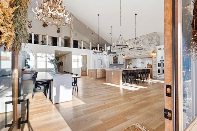 a kitchen with stainless steel appliances granite countertop a sink a stove top oven a chimney and a bookshelf