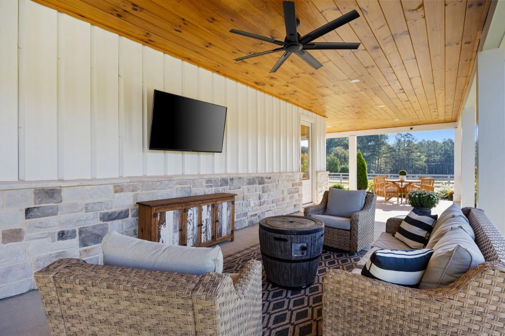125 Perry Road Rydal, GA 30171 - Photo 82 of 139 a living room with furniture a flat screen tv and a floor to ceiling window