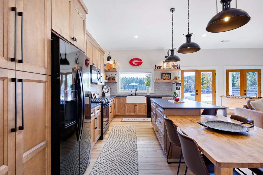 125 Perry Road Rydal, GA 30171 - Photo 88 of 139 a kitchen with stainless steel appliances granite countertop a refrigerator a sink dishwasher a dining table and chairs with wooden floor