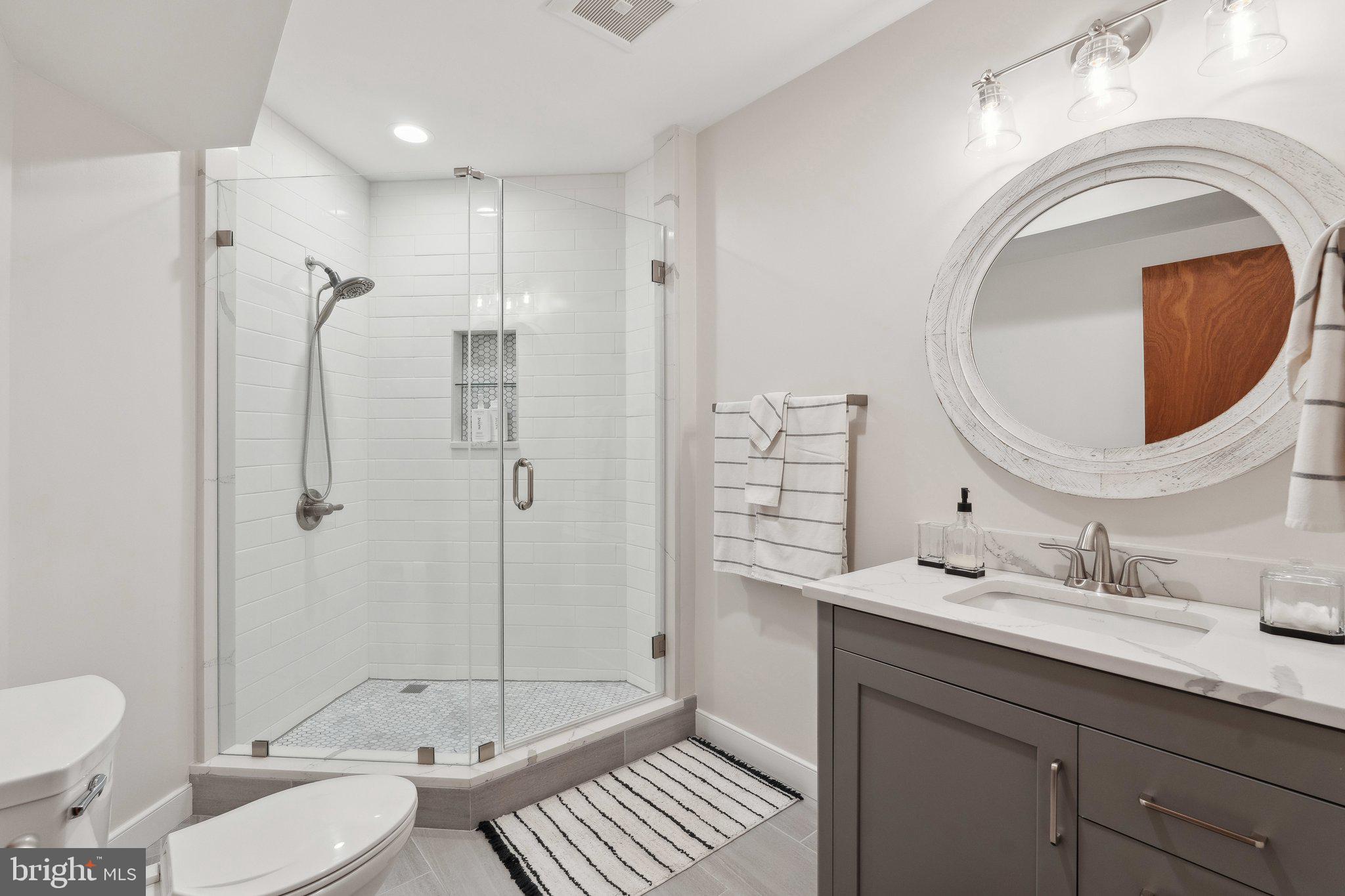 7514 A Evans Ford Road Clifton, VA 20124 - Photo 44 of 50 a bathroom with a granite countertop toilet sink shower and mirror