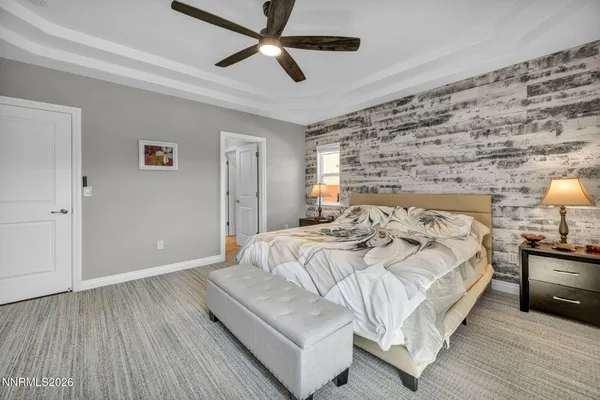 a spacious bedroom with a bed and a ceiling fan