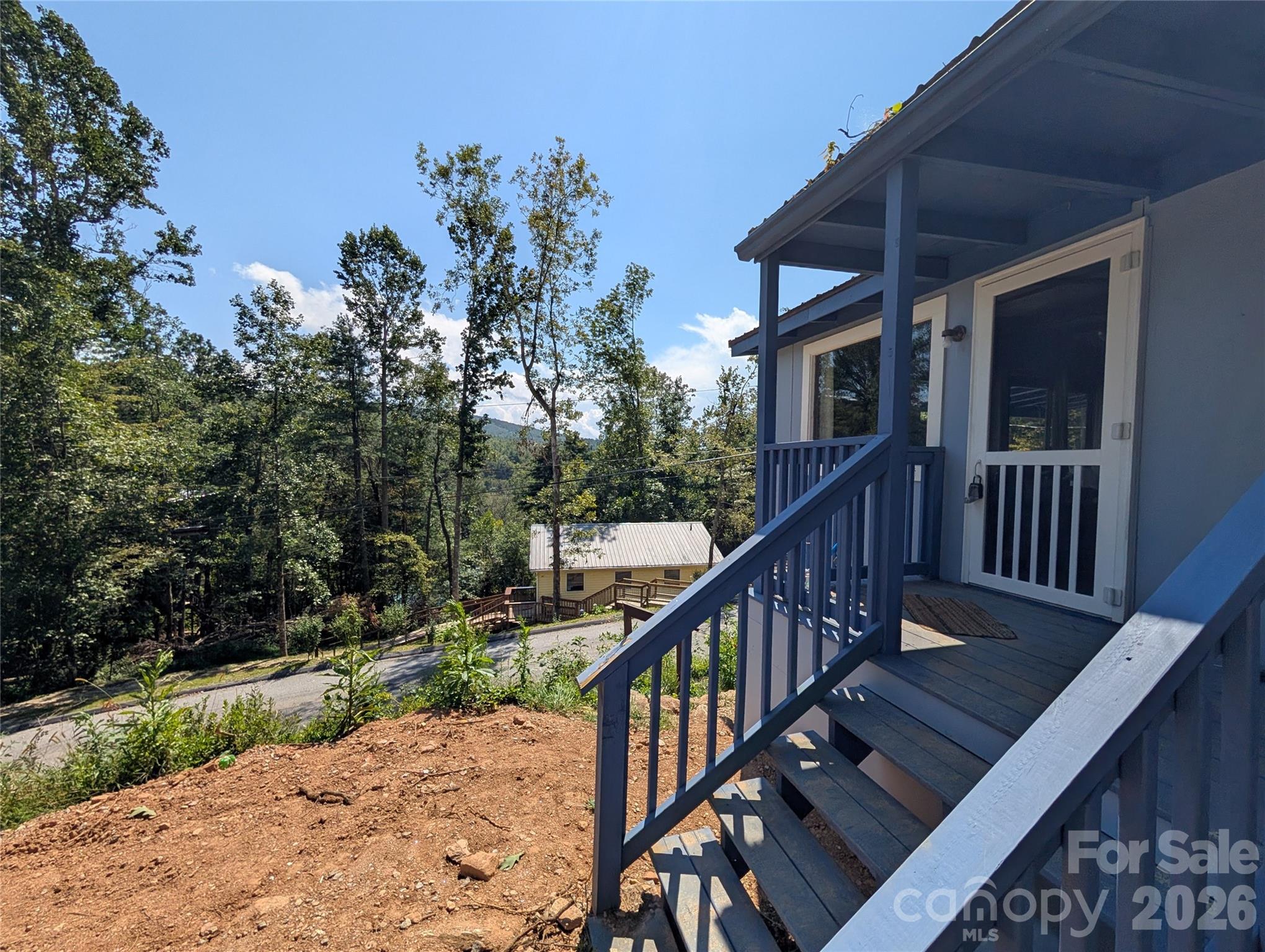 260 Oak Ridge Road Hendersonville, NC 28792 - Photo 2 of 24 a balcony with wooden floor and trees in the back