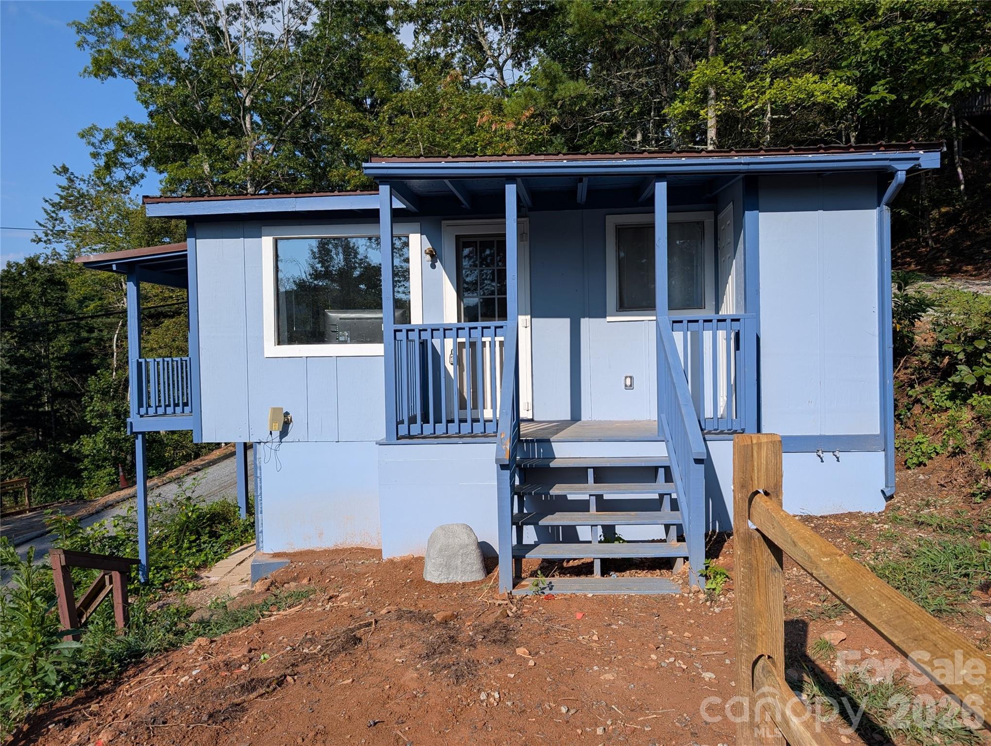 260 Oak Ridge Road Hendersonville, NC 28792 - Photo 8 of 24 a backyard of a house with wooden fence and a table and chairs