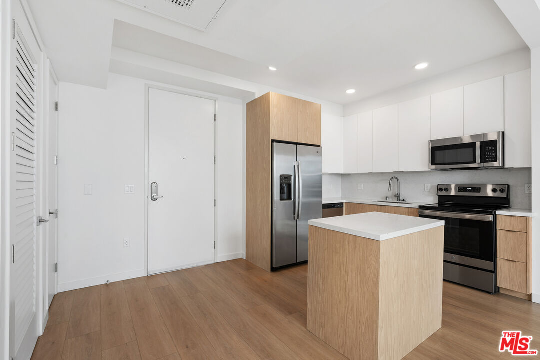 4406 Fulton Avenue, Unit 404 Sherman Oaks, CA 91423 - Photo 11 of 30 a kitchen with stainless steel appliances a refrigerator stove and microwave