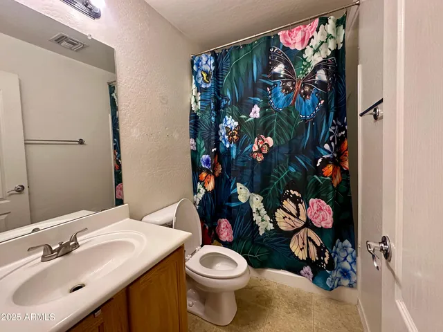 a bathroom with a sink mirror and toilet