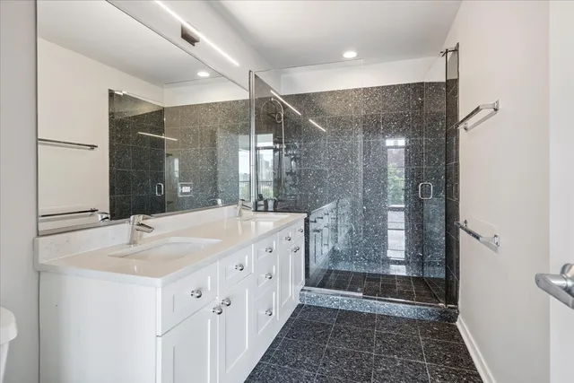 a bathroom with double vanity and a shower