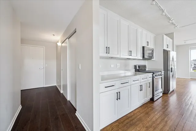 a kitchen with granite countertop white cabinets and white appliances