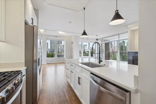 a open kitchen with stainless steel appliances granite countertop a sink and a refrigerator