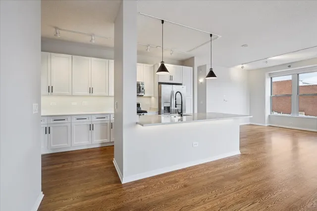 a view of a kitchen with wooden floor and a window