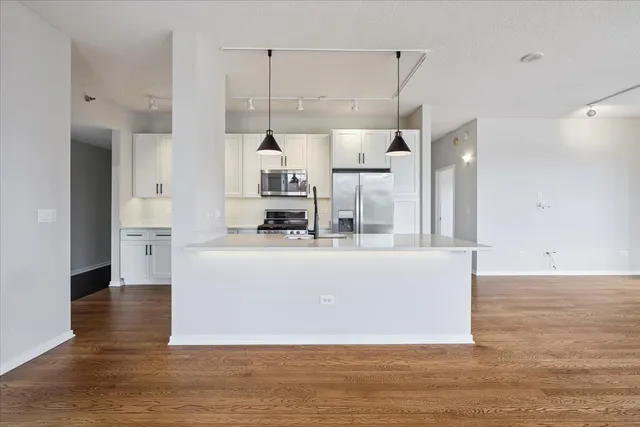 a living room with stainless steel appliances kitchen island granite countertop furniture